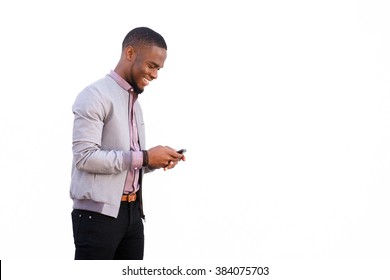 Side Portrait Of A Cheerful Young Black Guy Sending Text Message On Mobile Phone Against White Background