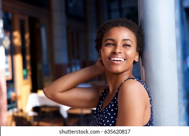 Side Portrait Of Elegant Young Black Woman Smiling Outside