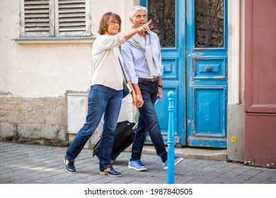 Side Portrait Happy Couple Walking On Street With Suitcase