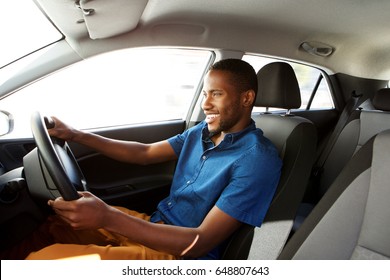 Side Portrait Of Happy Young African Male Driver Driving A Car