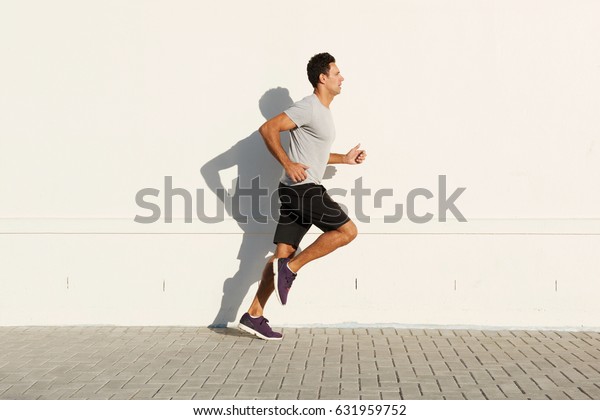 白い壁に沿って走る中年の男性の横のポートレート の写真素材 今すぐ編集