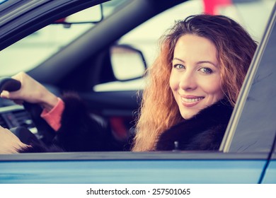 Side Portrait Smiling Attractive Happy Winter Woman, Buckled Up Driving Testing Her New Car, Automobile, Purchased At Dealership Isolated Street, City Traffic Background. Safe Driving Habits Concept