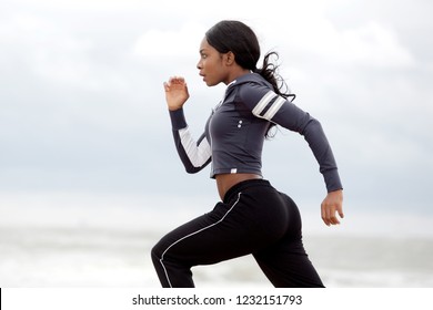 Side Portrait Of Sporty Young Black Woman Running