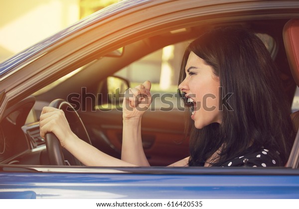 Side profile of an angry young driver.\
Negative human emotions face expression\
