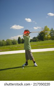 Side Profile Of A Boy Swinging A Golf Club