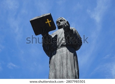 Side profile close up portrait of a statue of St. Ansgar praying with a bible in his hands on Brooksbrücke (Brooks Bridge), Hamburg, Germany