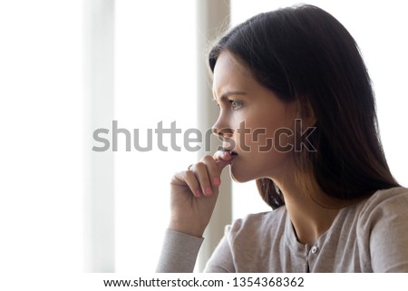 Side profile close up view face of serious pensive young woman thinking about problem difficulties biting nail finger, feels nervous frustrated puzzled, hard make decision stressful situation concept