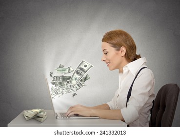 Side profile happy smiling business woman working online on computer earning money dollar bills banknotes flying out of laptop screen isolated grey wall office background. Human face expression 