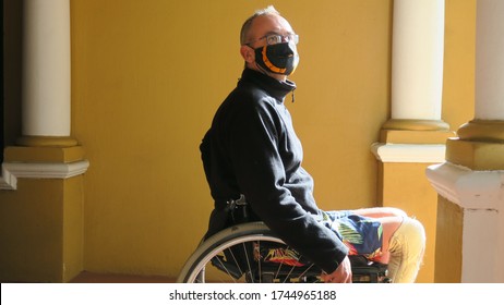 Side Profile Of Man Wearing Facemask, The Man Is A Paraplegic Sitting In His Wheelchair