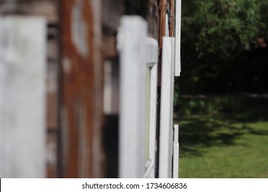 Side Profile Of Old Playhouse With White Wooden Windows