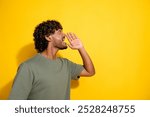 Side profile photo of cheerful guy with wavy hair dressed khaki t-shirt look at sale empty space yell isolated on yellow color background