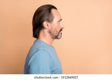 Side Profile Photo Portrait Of Serious Man Wearing Blue Sweatshirt Isolated On Pastel Beige Color Background