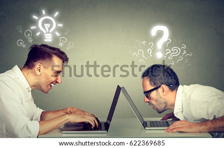 Side profile two men using laptop computer one educated has bright ideas the other ignorant has many questions. Level of technology education concept  