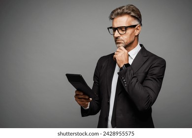 Side profile view adult minded successful employee business man corporate lawyer in classic formal black suit shirt tie work in office use calculator isolated on plain grey background studio portrait - Powered by Shutterstock