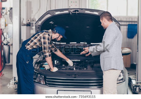 Side profile view of experienced brunet bearded\
expert specialist in cap, uniform appraising the broken damage,\
businessman in classy suit is asking and gesturing, discussing,\
diagnostic, upgrading