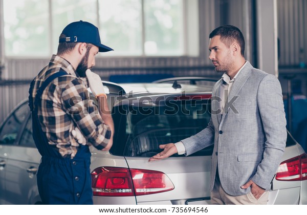 Side\
profile view of experienced brunet bearded expert specialist in cap\
and uniform and businessman in classy suit, presenting his car\
broken demage, discussing it, diagnostic,\
upgrading