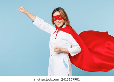 Side profile view female happy doctor man wear white medical gown suit red super hero coat mask work in hospital do fly gesture isolated on plain blue background studio. Healthcare medicine concept - Powered by Shutterstock