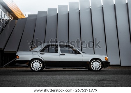 Side profile view of a German two tone zilver and black classic car with long antenna at a beautiful photo location