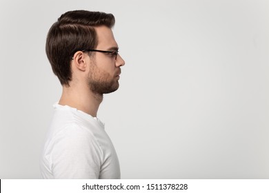 Side Profile View Head Shot Close Up Young Man In Glasses Standing On Left Side, Looking At Blank Copy Space For Product Promo, Good Deal, Opportunity Advertising, Isolated On Grey Studio Background.