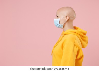 Side Profile View Young Bald Woman 20s Without Hair In Yellow Casual Shirt In Sterile Face Mask To Safe From Coronavirus Covid-19 During Quarantine Look Aside Isolated On Pastel Pink Background Studio