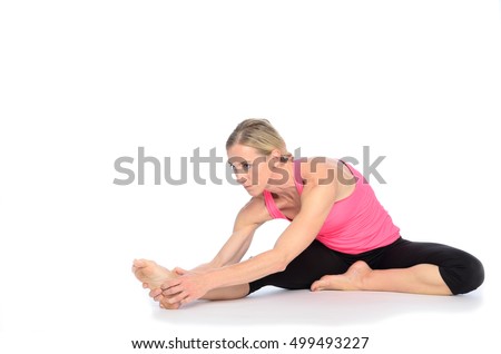 Side rear view on woman performing abdominal strengthening exercises with legs raised and arms reaching forward