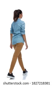 Side Rear View Of Smart Casual Woman Walking And Wearing Shirt On White Studio Background