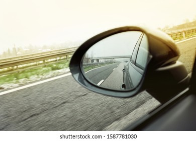 Side Rear-view Mirror On A Car. Road In The Sideview Mirror Of A Car 