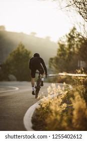 Seitenaufnahme eines professionellen schlanmigen Radfahrers auf einem Berg
