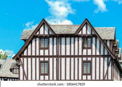 The Side Of A Tudor Revival Building With One Open Window.