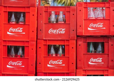 Side, Turkey -January 30, 2022: close-up of empty glass bottles of coca cola in branded crates ready for recycling