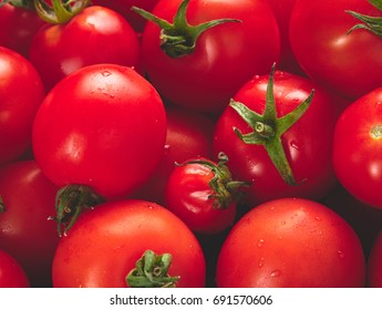 A side view, 45 degree angle view of a tray of bright red ripe tomatoes.