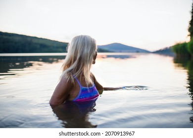 Side View Of Active Senior Woman Swimmer Diving Outdoors In Lake.