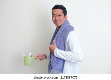 Side View Of Adult Asian Man Smiling While Bring Shower Dipper And Towel Around His Neck