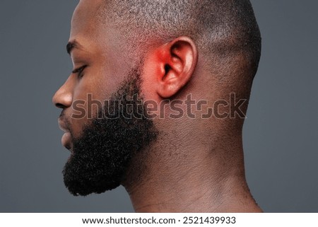 Side view of afro man with inflamed ear, close up