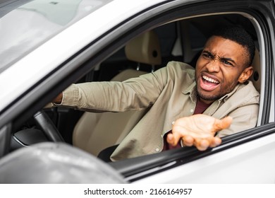 Side View Of An Angry Black Man Driving A Car