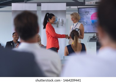 Side view of Asian businesswoman receiving award in a business seminar. International diverse corporate business partnership concept - Powered by Shutterstock