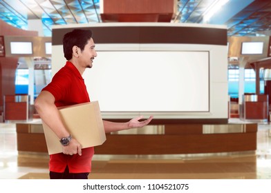 Side View Of Asian Delivery Man Send A Parcel On The Building