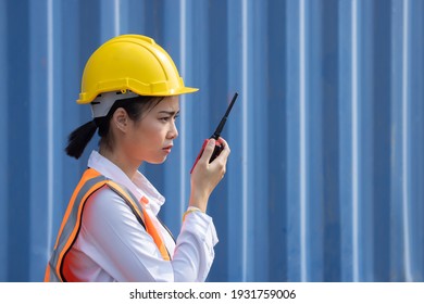 Side View of Asian Logistic Worker woman in Uniform Talking on Walkie Talkie to Communicate with Other Workers