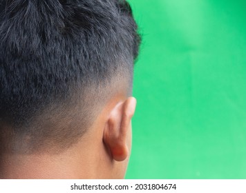 Side View Of Asian Male Haircut Model Isolated On Green Background.