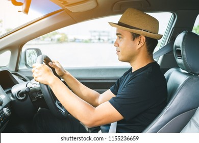 Side View Of Asian Man Driving Car.
