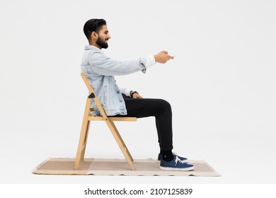 Side view of Asian man sitting in the armchair while watching TV in the studio - Shutterstock ID 2107125839