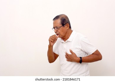 Side view of asian old man standing while coughing and holding his chest. Isolated on white - Shutterstock ID 2181846171