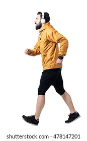 Side view of athlete jogging with headphones wearing jacket. Toned desaturated full body length portrait isolated on white studio background.  - Shutterstock ID 478147201
