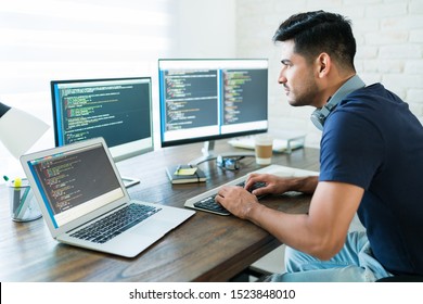 Side View Of Attractive Hispanic Software Developer Programming Using Computer While Working From Home