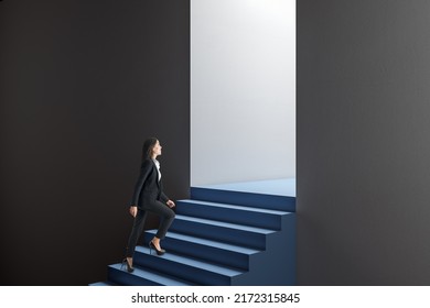 Side view of attractive thoughtful young european business woman walking in abstract concrete wall opening with blue stairs and mock up place. Door, opportunity and success concept