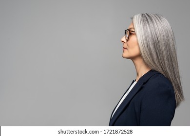 side view of beautiful asian businesswoman with grey hair in eyeglasses isolated on grey
