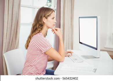 Side View Of Beautiful Woman Using Computer At Home