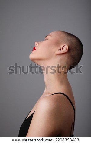 Similar – Portrait of a young, very short-haired woman wearing an off-the-shoulder top through which you can see her nipples