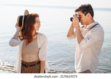 Side view beautiful young couple two family man woman in white clothes boyfriend take photo on camera of girlfriend rest date at sunrise over sea sand beach ocean outdoor seaside in summer day sunset - Powered by Shutterstock