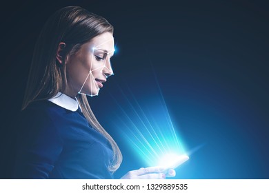 Side View Of Beautiful Young Woman Looking At Her Smartphone With Face Recognition Technology. Concept Of Hi Tech. Toned Image